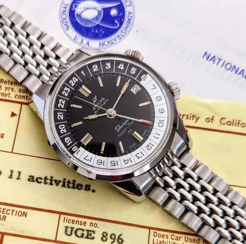 Sherpa Super-Jet MkI with a black dial, black and silver 24-hour bezel and red-tipped GMT hand, on a steel bracelet, photographed on period paperwork